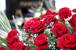 Rote Rosen vor einem Grabstein