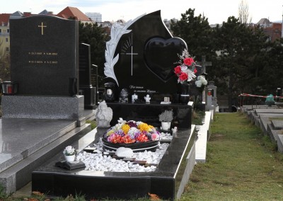 Schwarzes Grab mit Grabstein in Segelform mit einem Herz